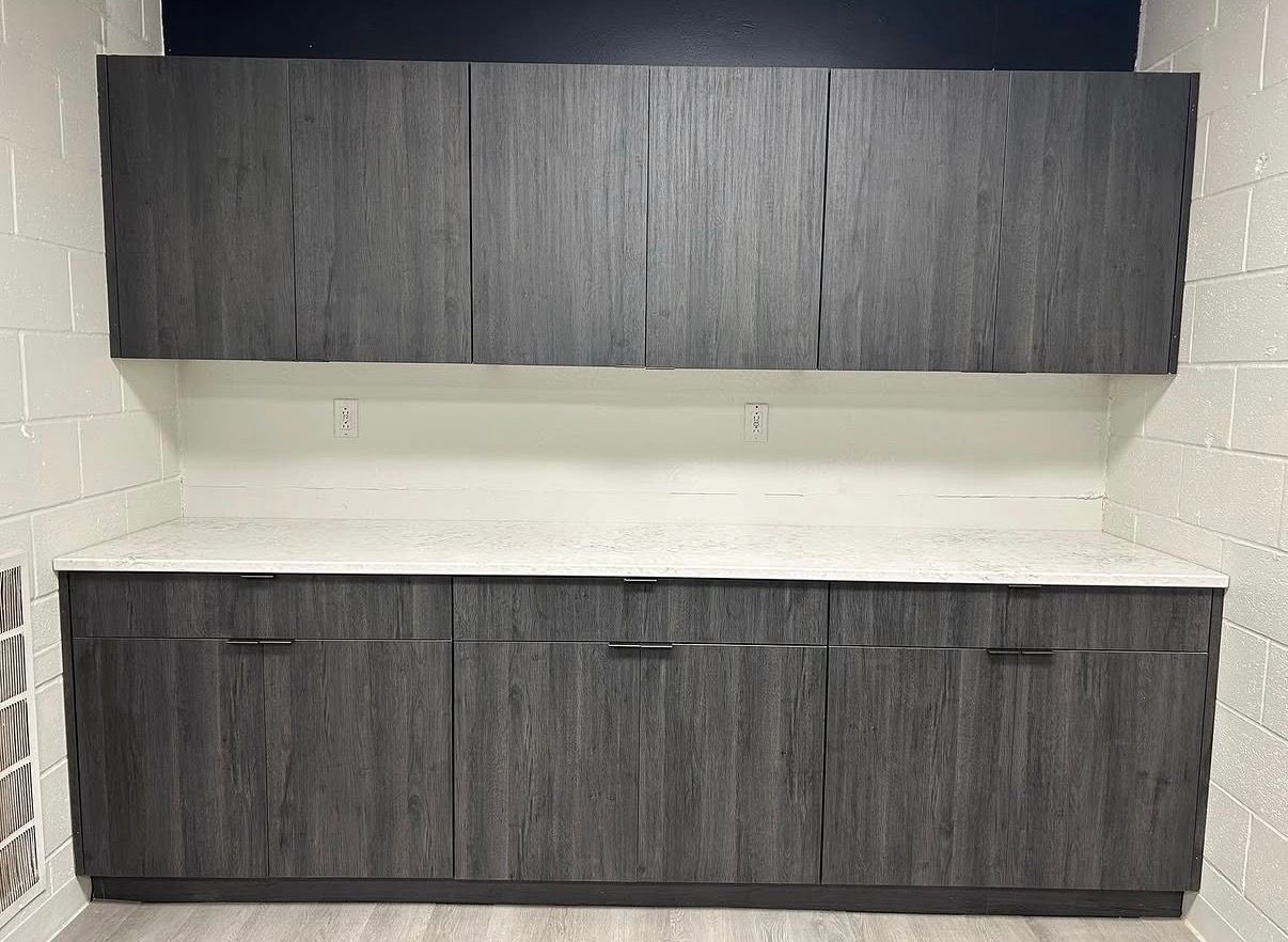Two dark wood cabinets mounted on a white wall, one above the other.