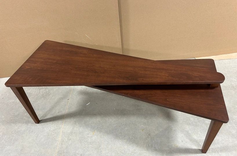 Walnut triangular nesting tables with angled legs on a light floor