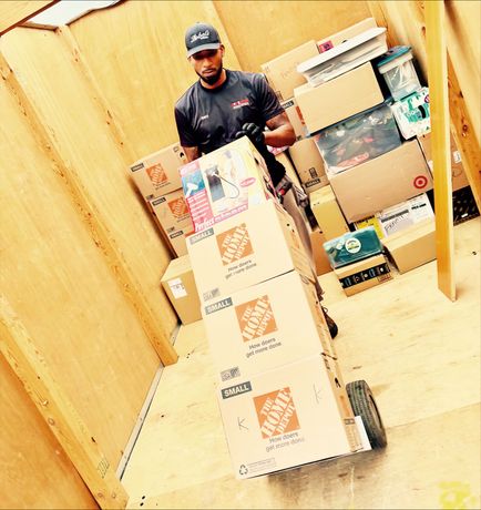 A moving truck filled with boxes and blue bags