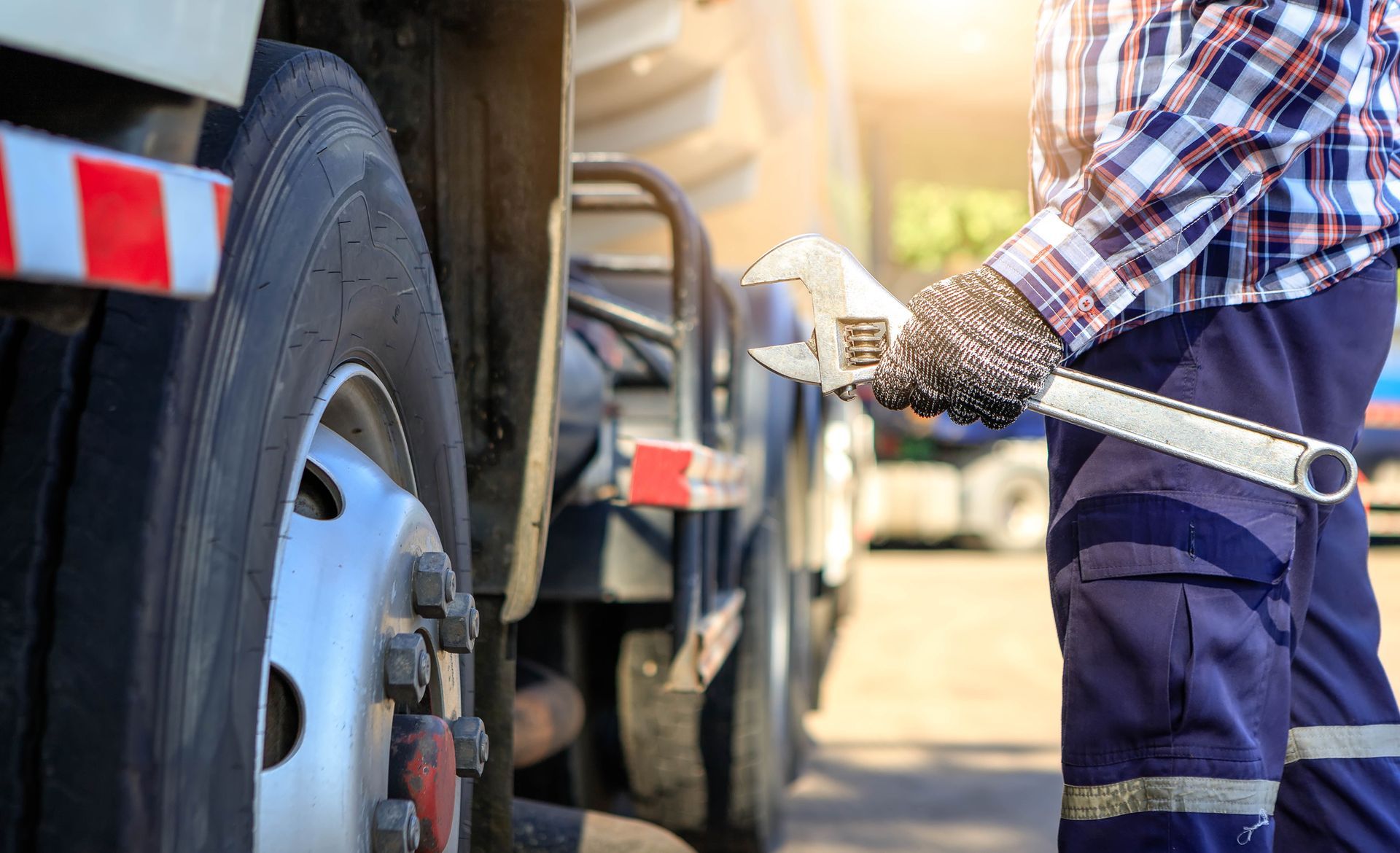 Truck maintenance technician inspecting and servicing a commercial vehicle for safe operation.