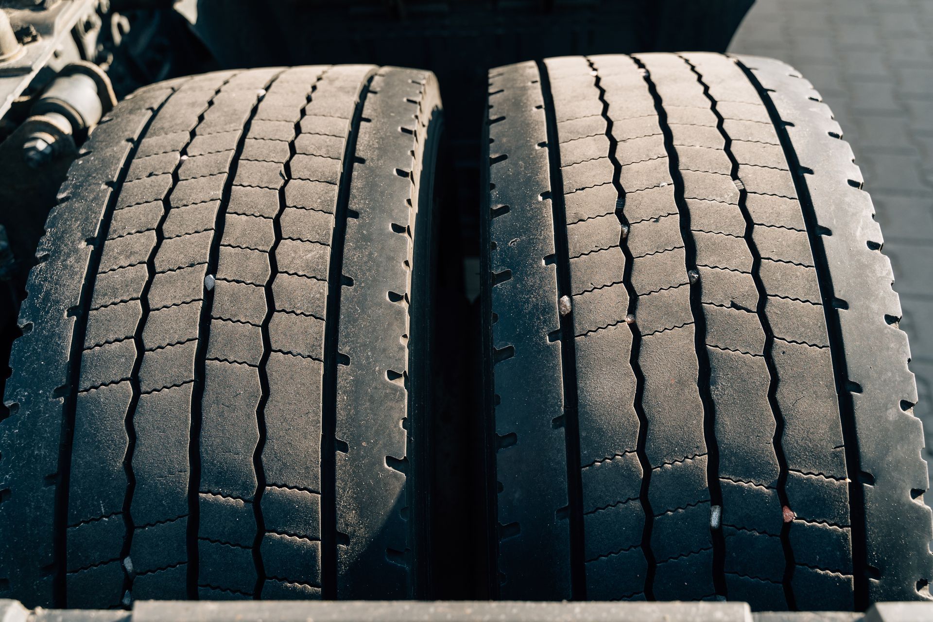 Close-up of two worn truck tires with visible tread grooves and sidewall wear