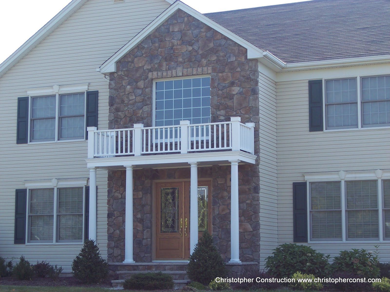 Two-story brick-and-siding house with white balcony and front door