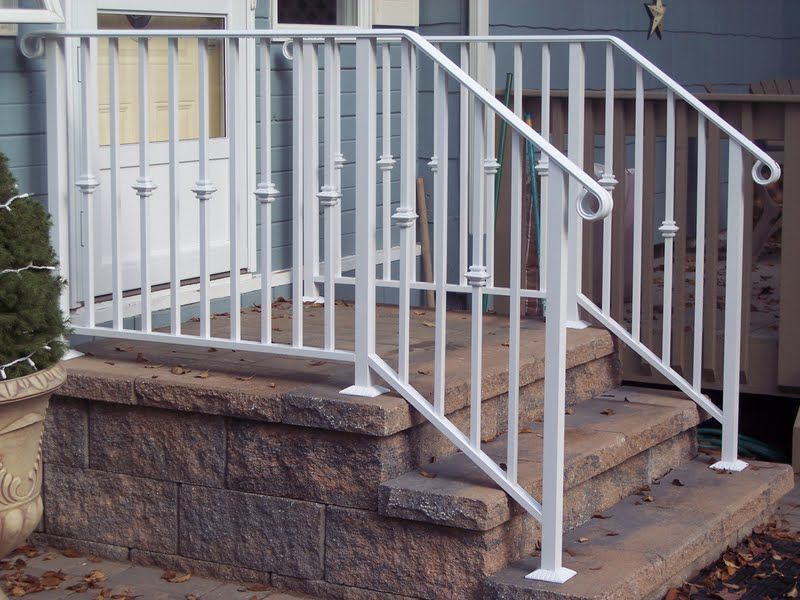 White porch railing and steps leading to a front entrance on a stone foundation