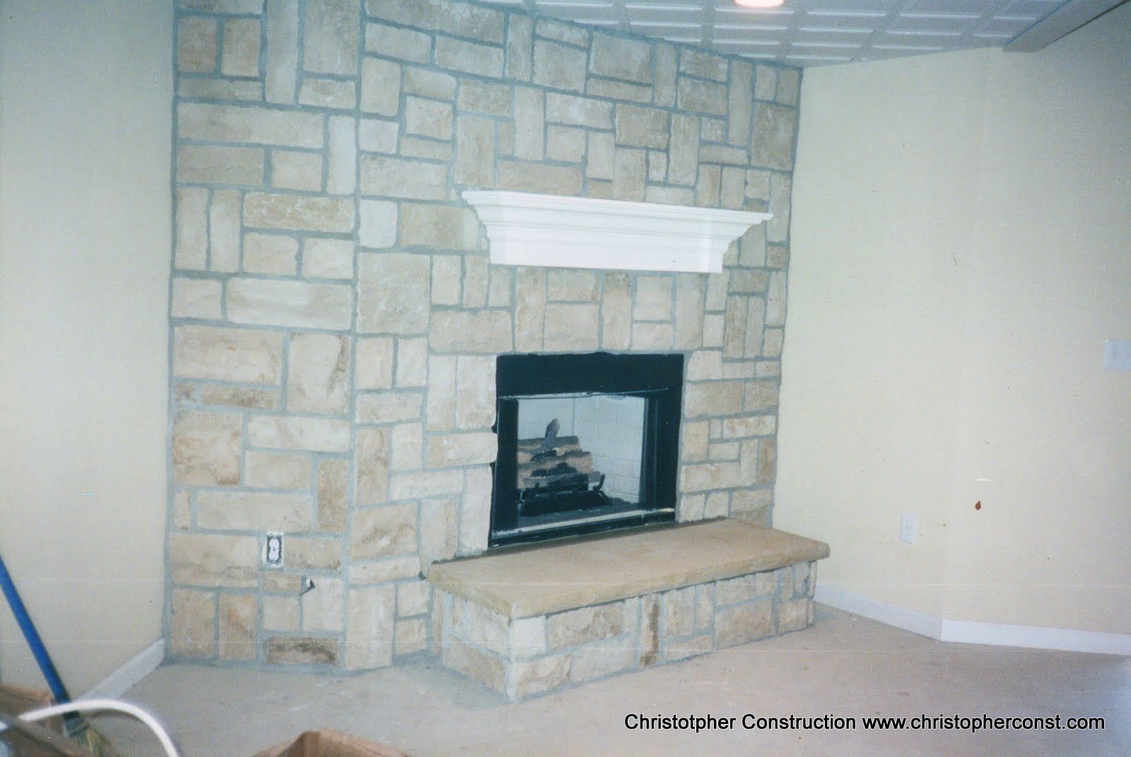 Stone fireplace with white mantel in a beige room