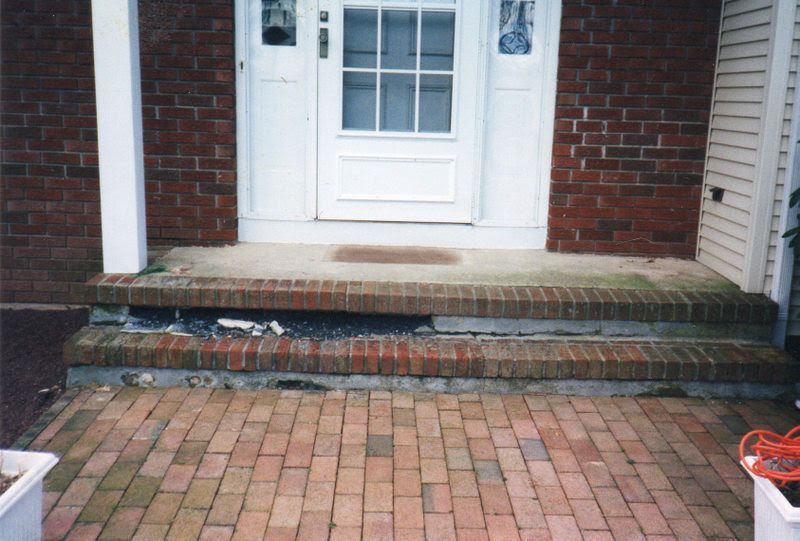 Brick steps leading to a white front door with a small landing and brick walkway.