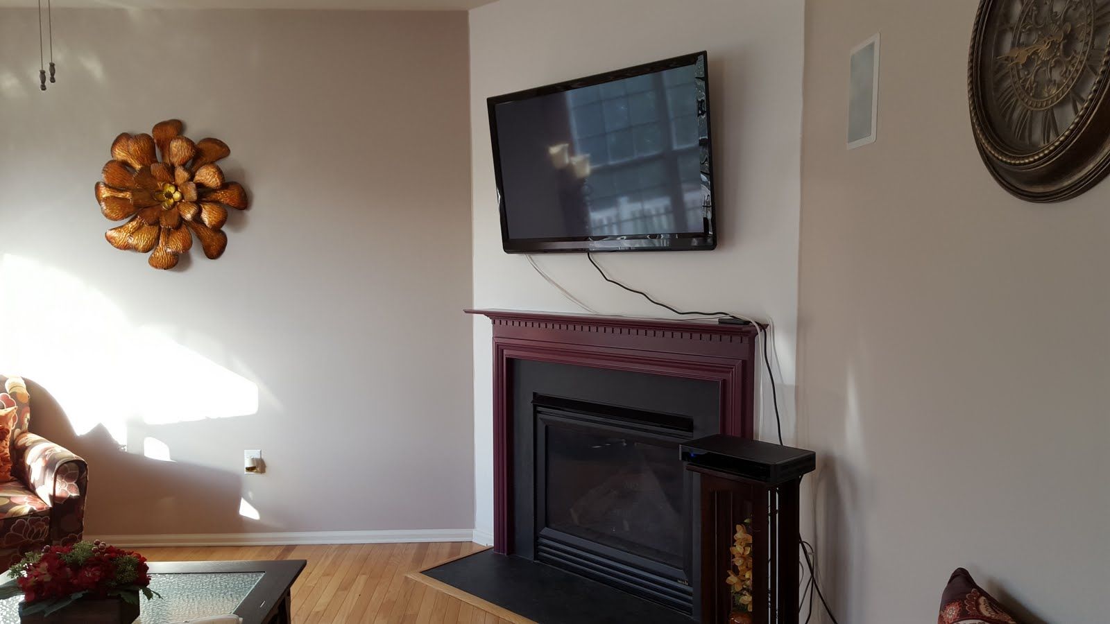 Living room with wall-mounted TV above a fireplace and decorative wall art