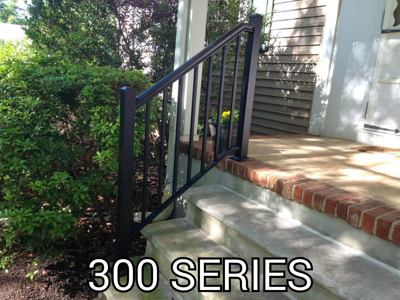 Black metal porch railing beside brick steps and a house exterior, with “300 SERIES” text.