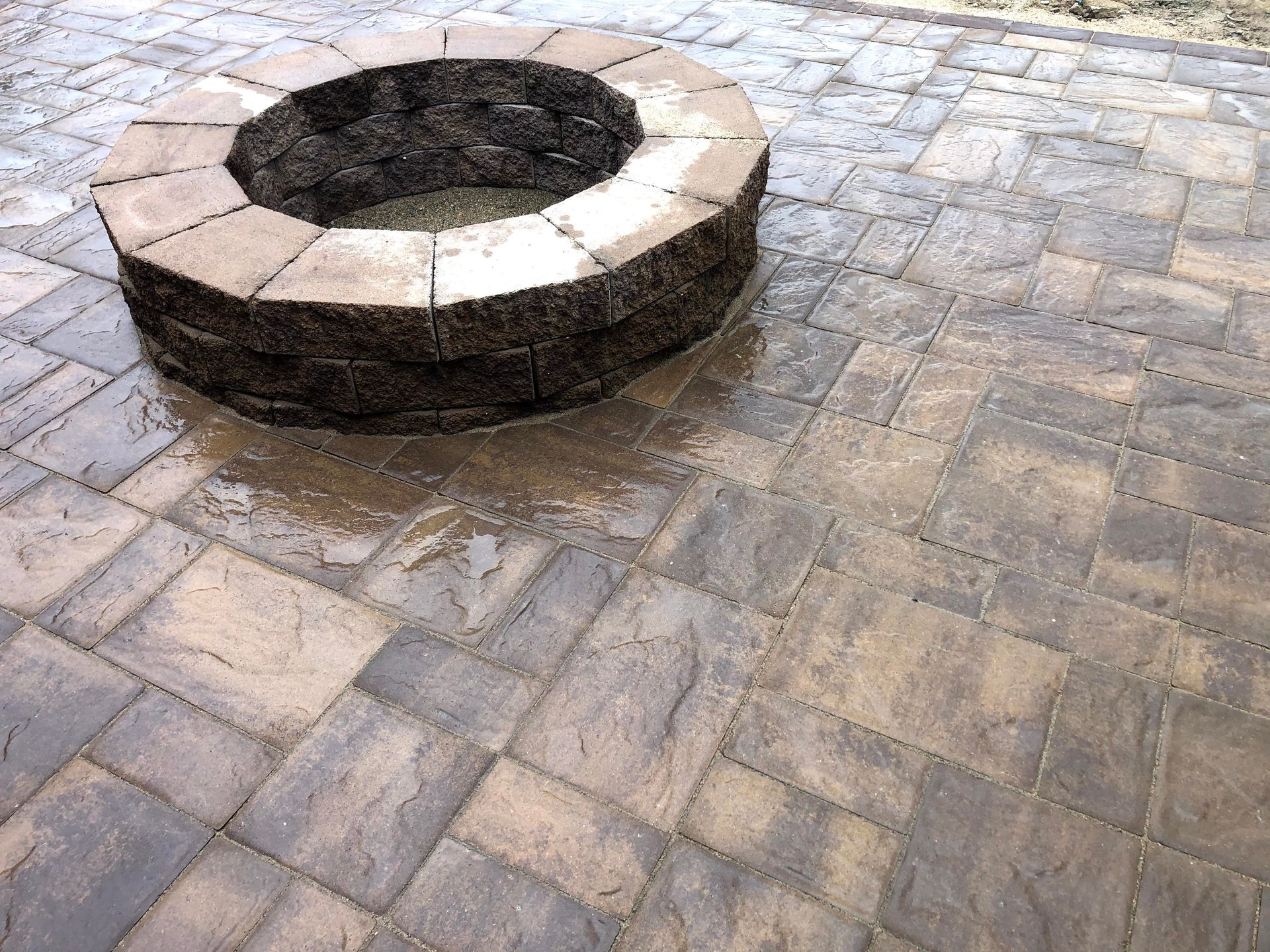 Stone fire pit on a wet brick courtyard