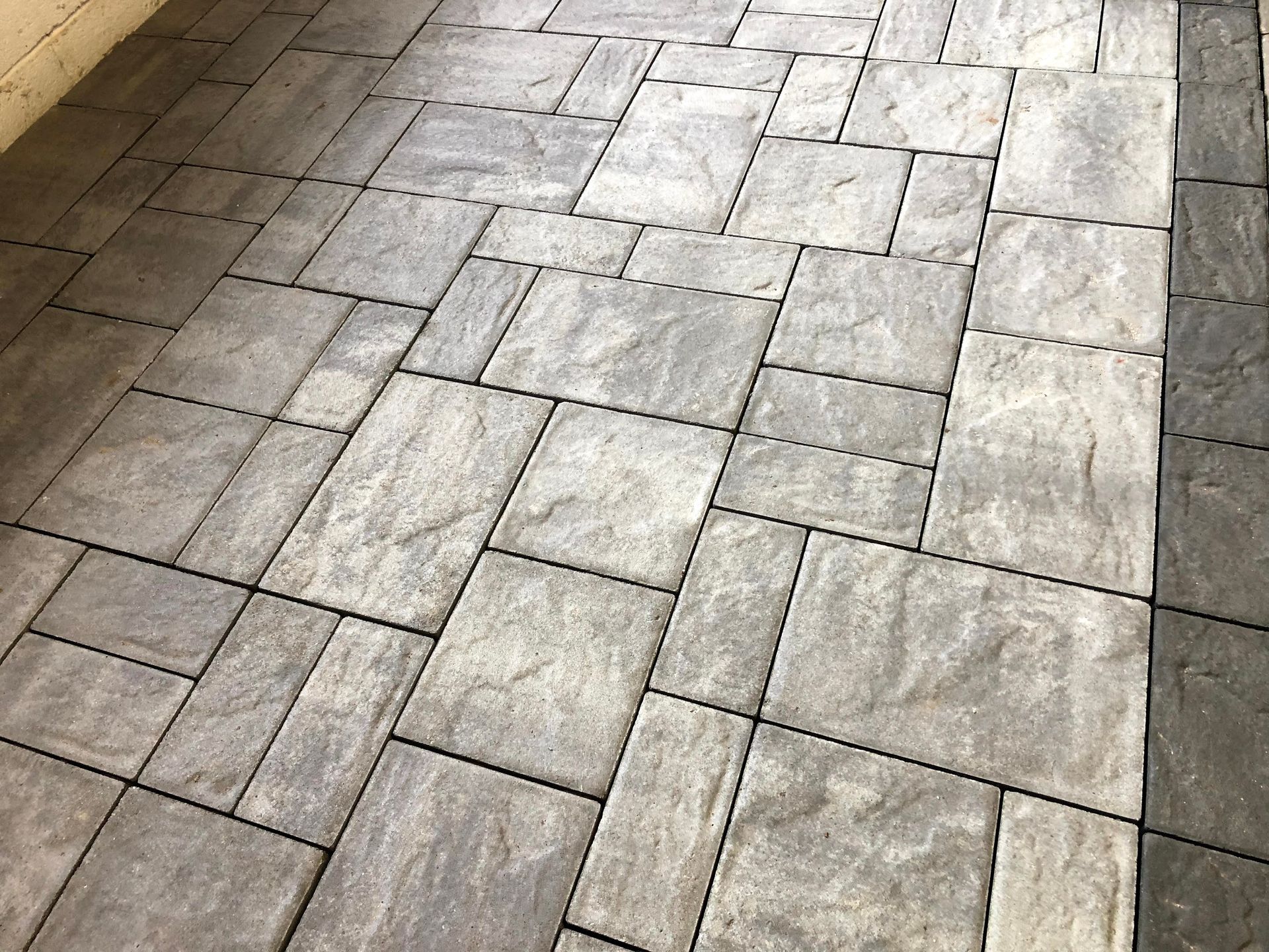 Gray stone-tiled pavement with a diagonal seam and dark border edges