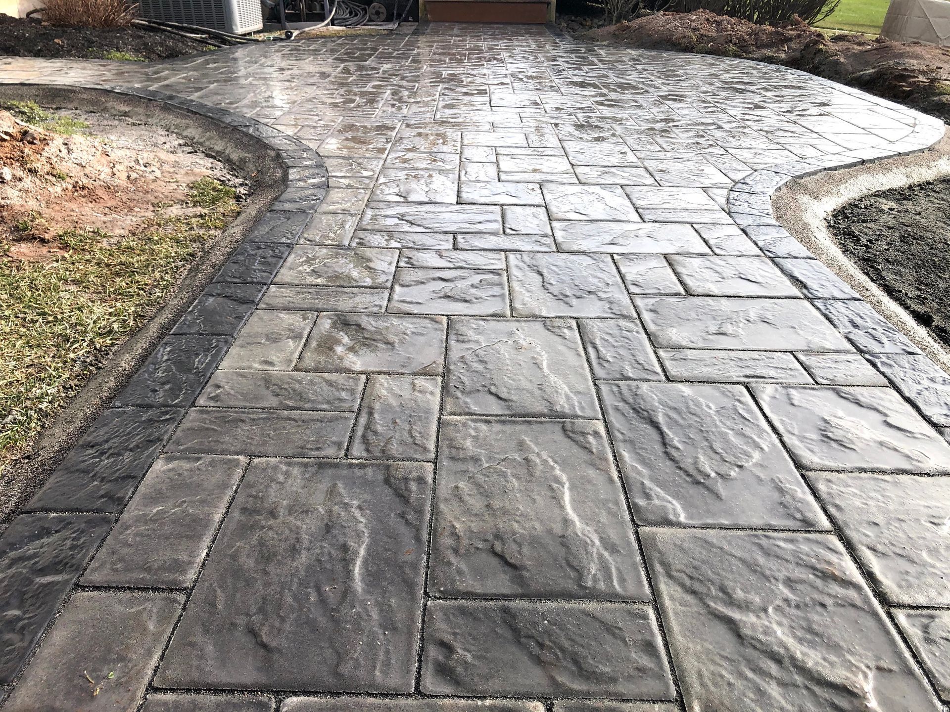 Stone-paved garden walkway curving through landscaped beds