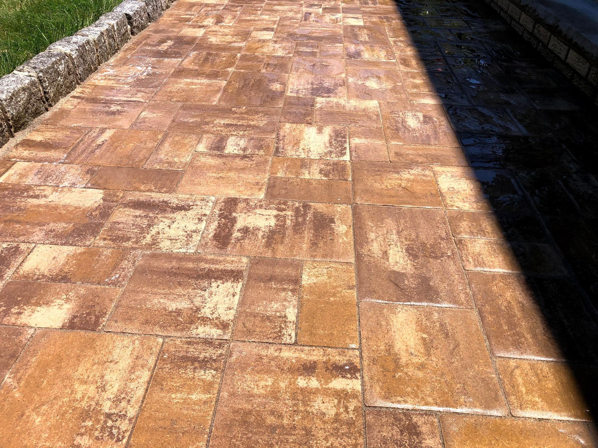 Sunlit brick walkway with a dark shadow along the right edge