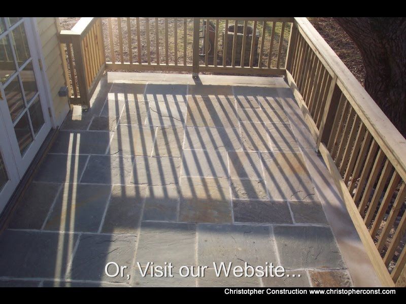 Wooden deck with railing casting striped shadows in warm sunlight