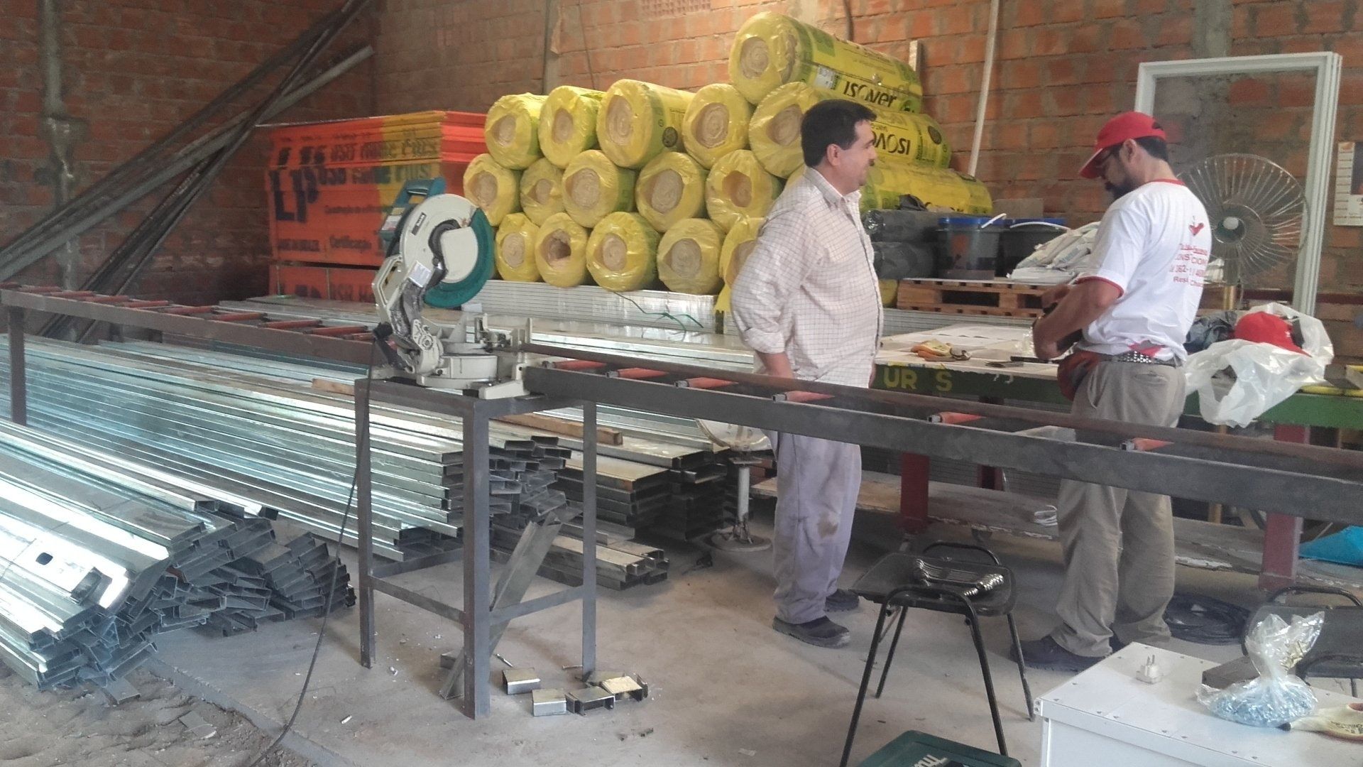 Trabajadores manipulando materiales en una cinta transportadora de un almacén
