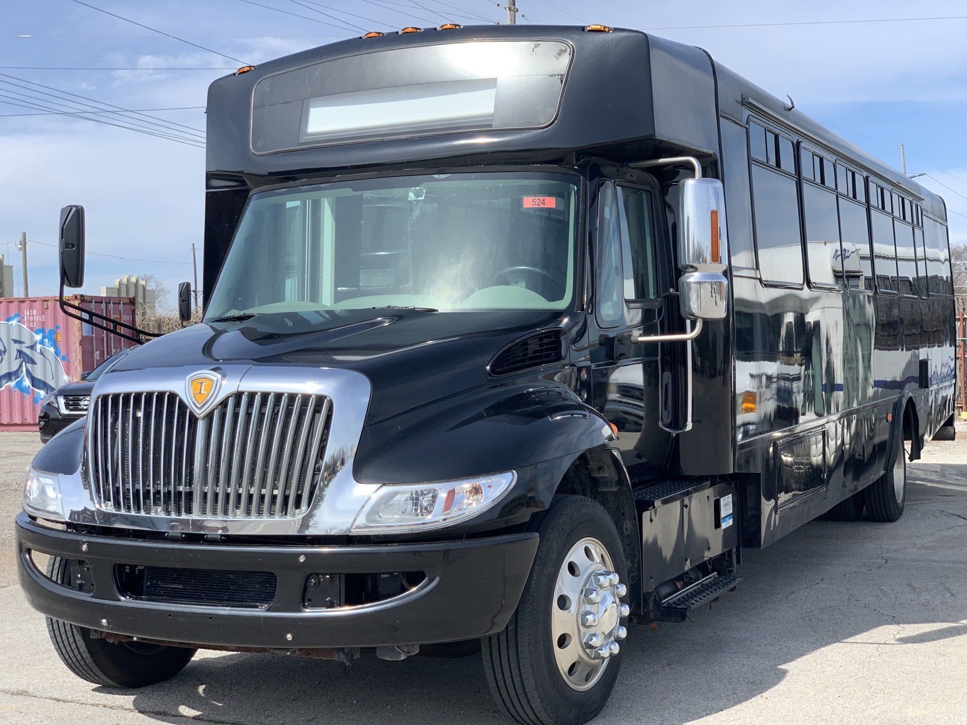 A black and silver bus is parked in a parking lot.