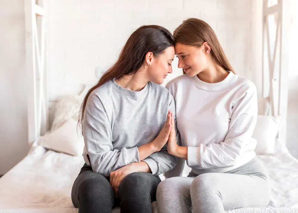 Lesbian couple sharing a close moment while sitting together