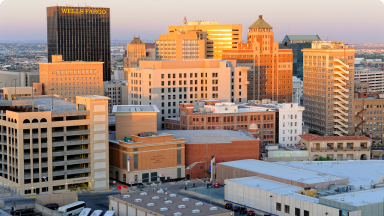 Downtown El Paso skyline at sunset with gold and warm light.