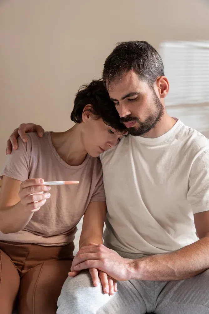 Couple reviewing pregnancy test during fertility treatment journey, woman holding the test.