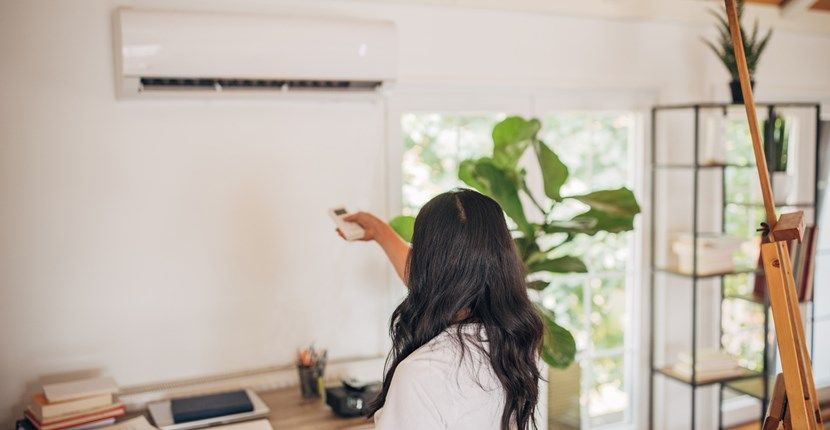 A person adjusting an AC unit.