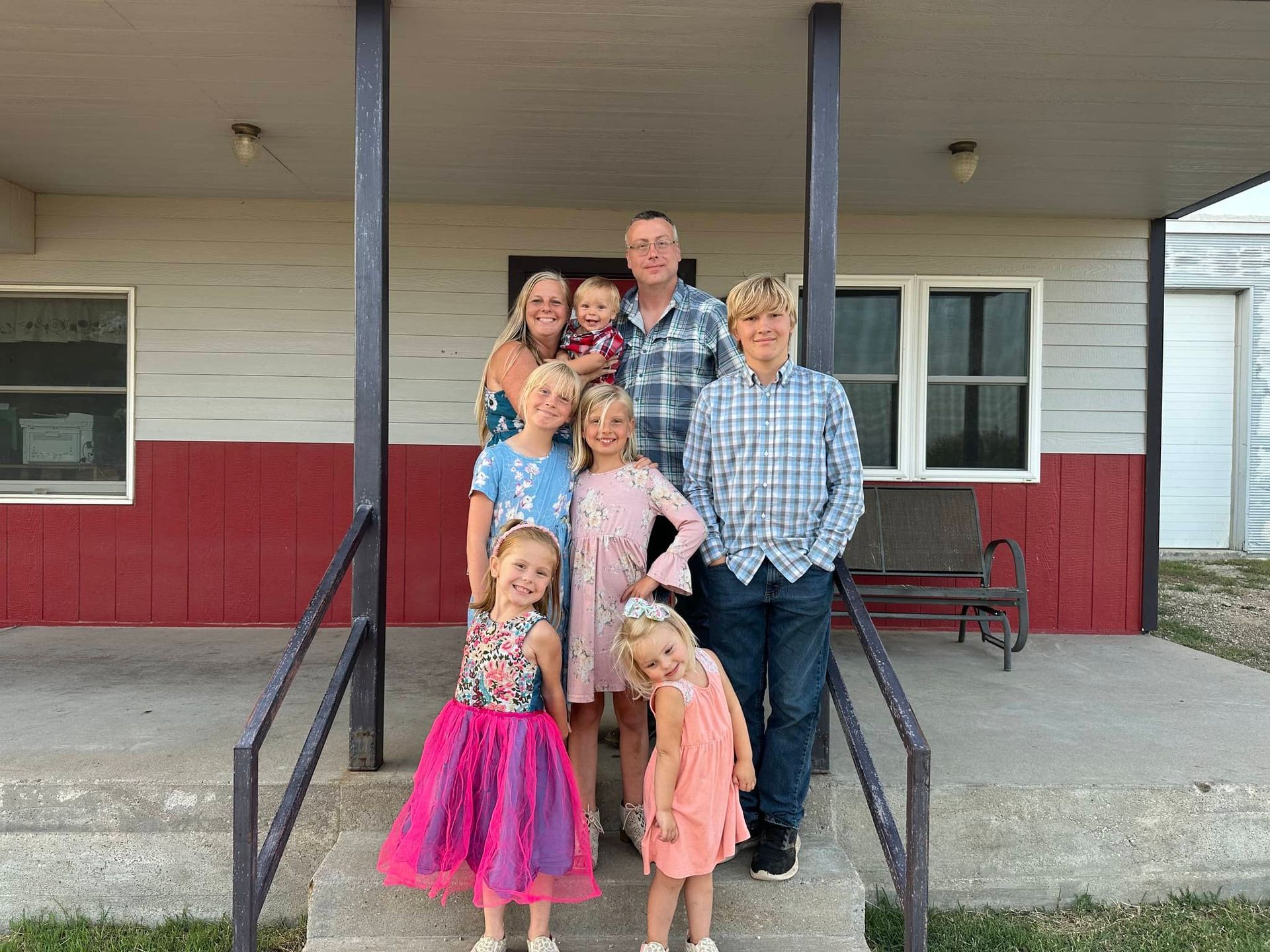 a family posing for a picture in front of a house