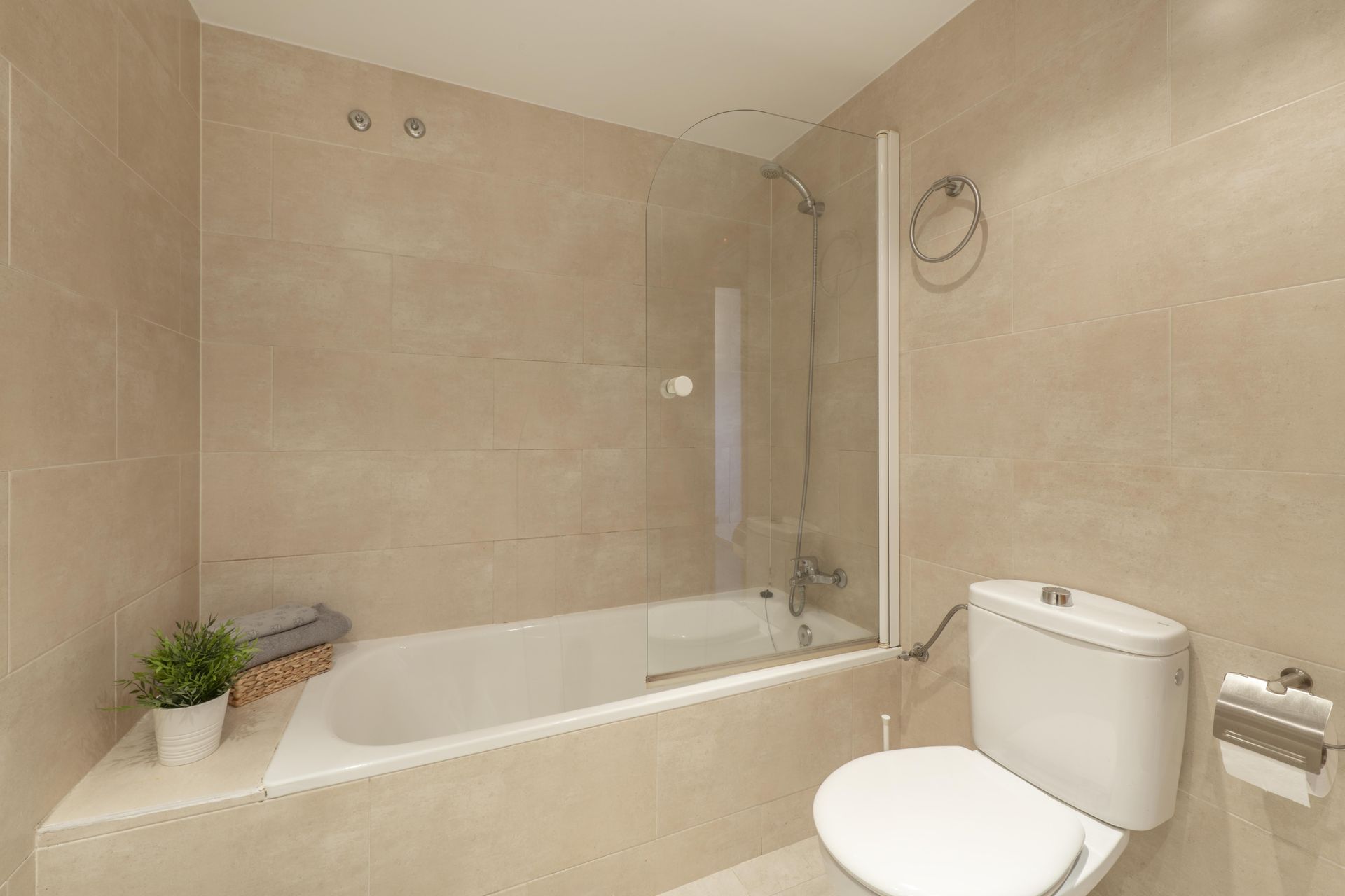 A bathroom with a toilet , bathtub and shower.