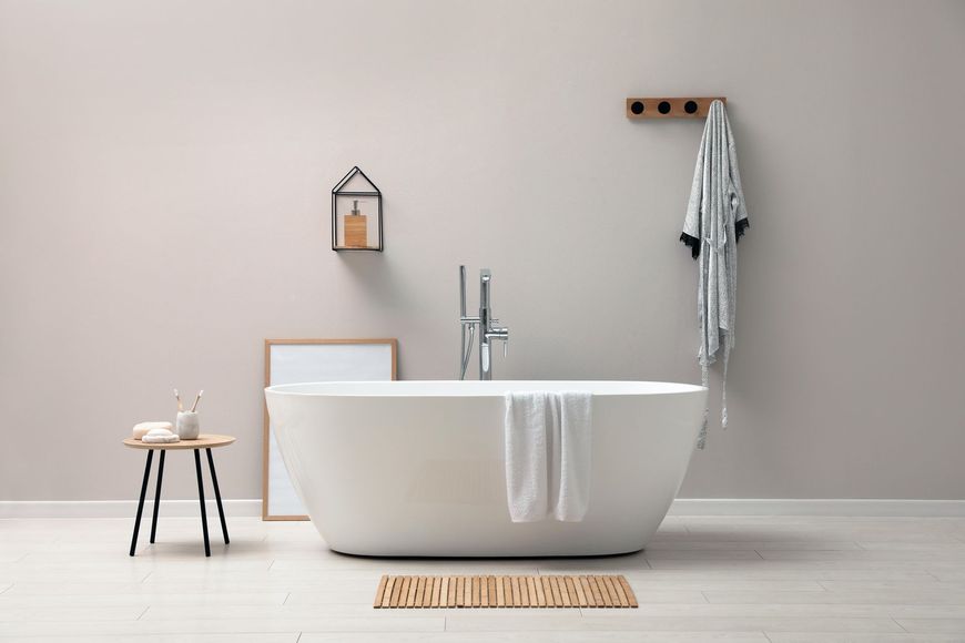 A bathroom with a bathtub , stool , and towel rack.