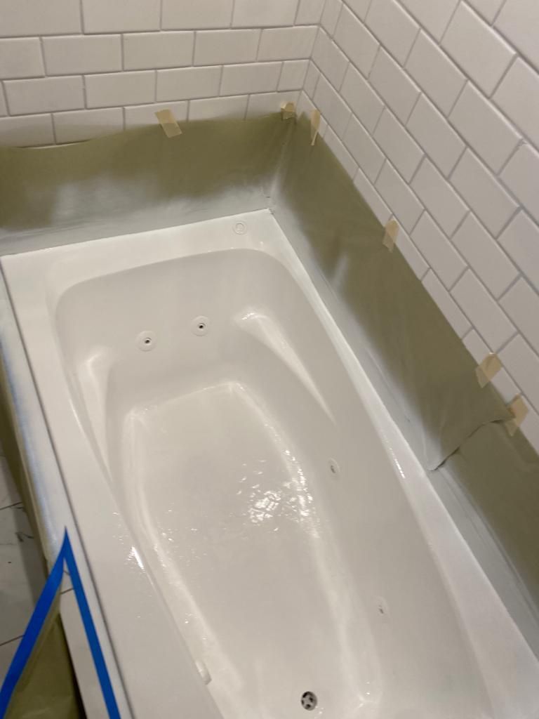 a bathtub is sitting in a bathroom next to a brick wall .