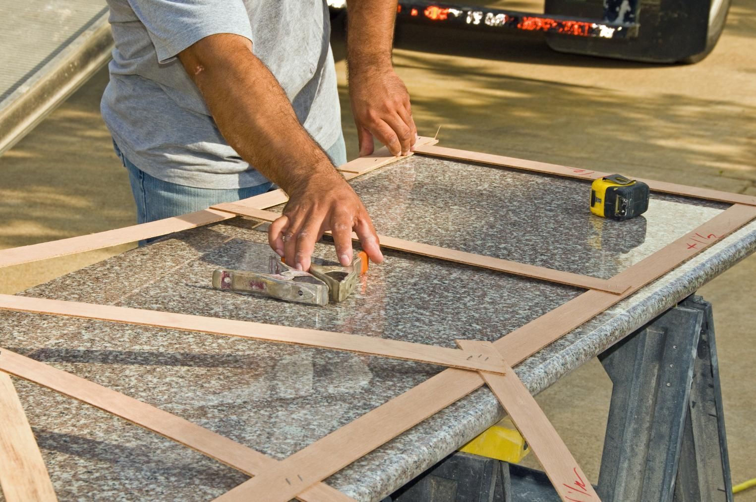 a man is measuring a piece of glass with a tape measure