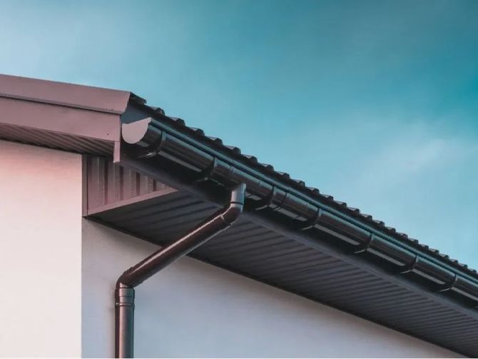A close up of a gutter on the roof of a house.