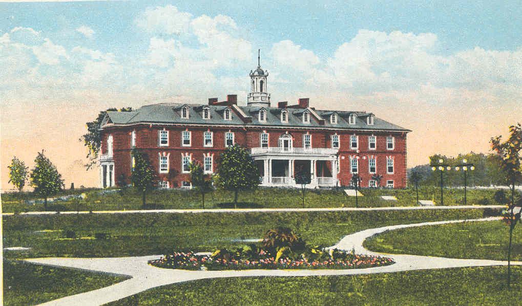 Historic red-brick mansion with white columns and a central cupola, set behind landscaped gardens