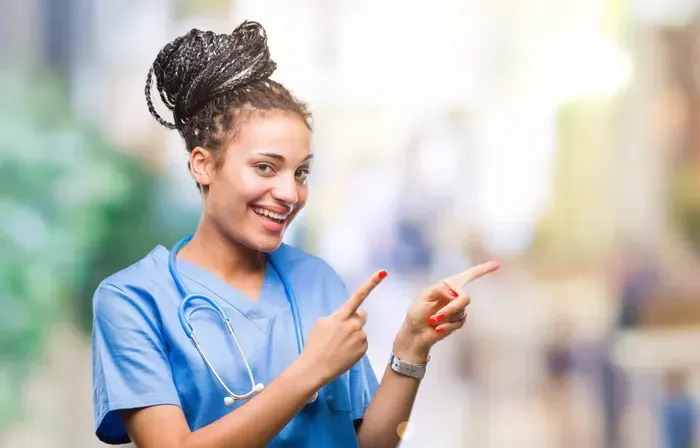 Eine Krankenschwester zeigt mit beiden Händen zur Seite.