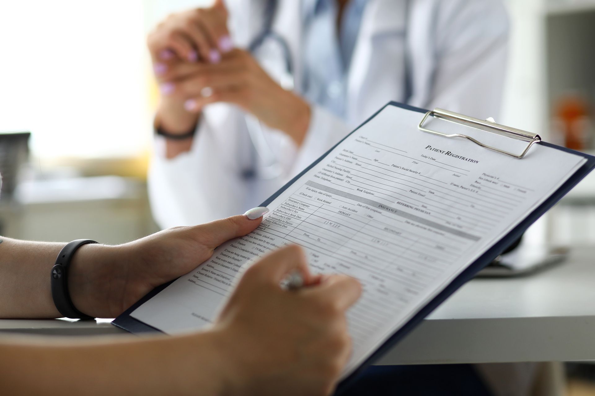 Ein Arzt spricht mit einem Patienten, der ein Klemmbrett in der Hand hält.