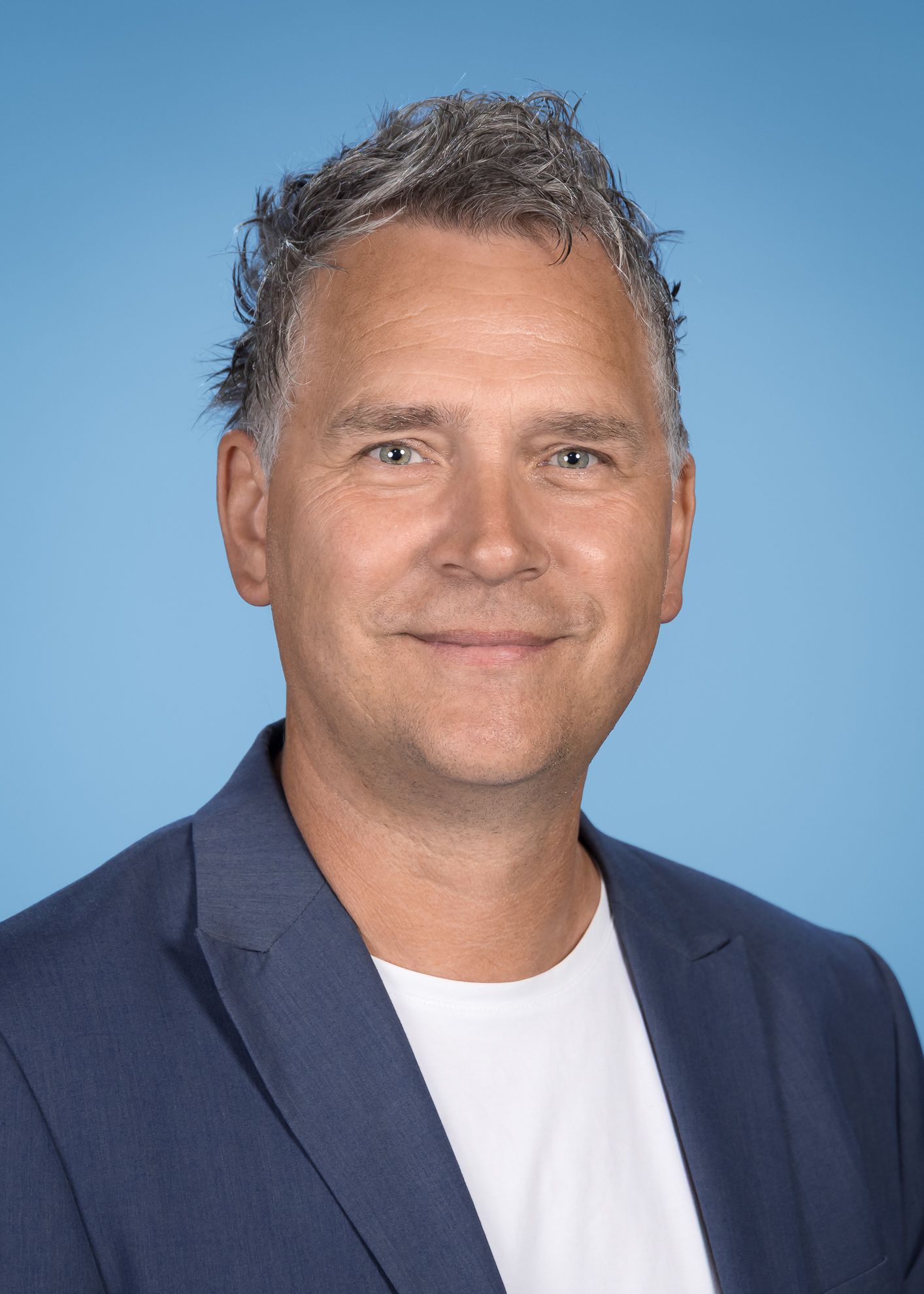 Ein Mann in Anzug und Krawatte mit Brille und Schnurrbart