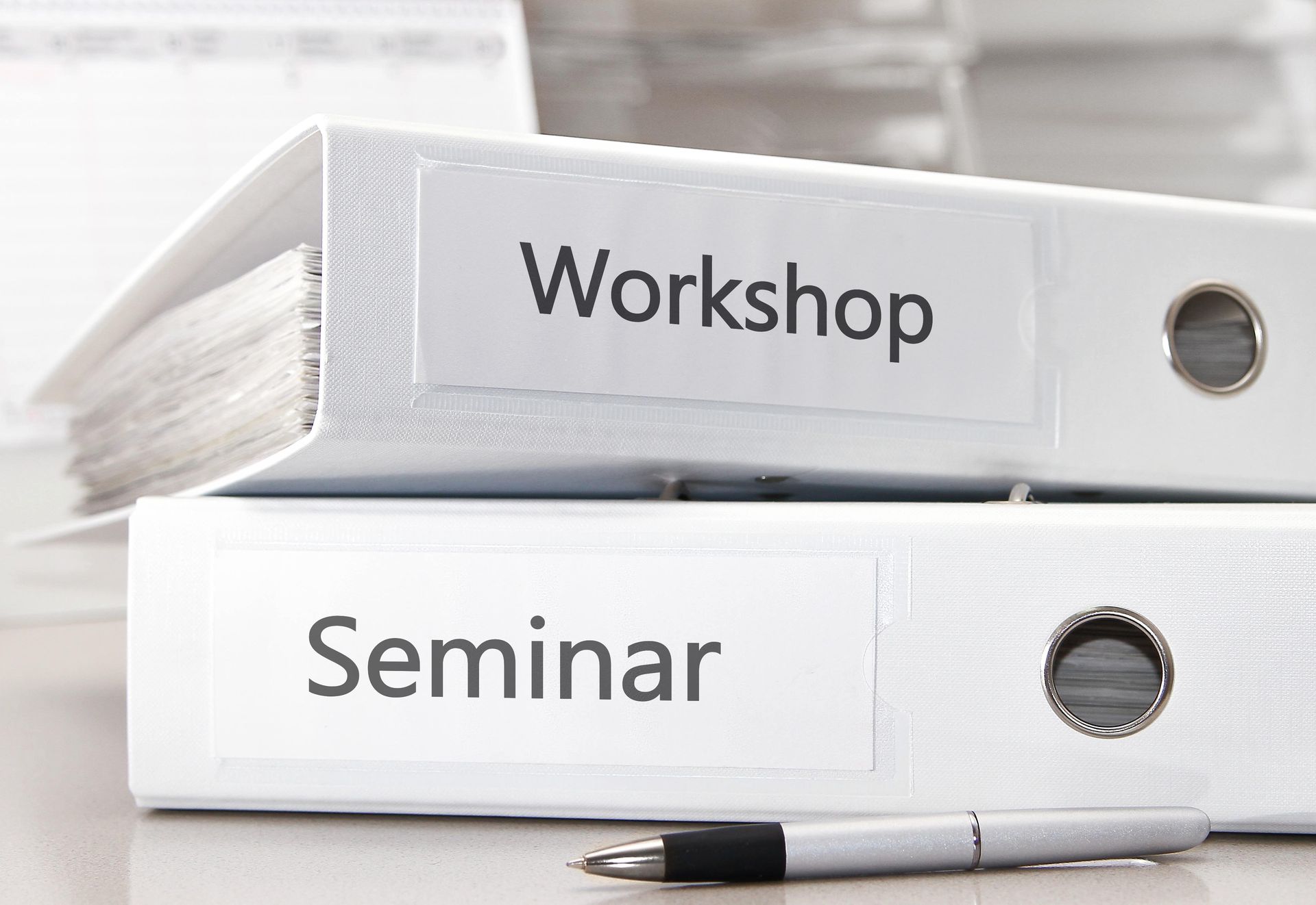 Zwei weiße Ordner mit den Aufschriften „Workshop“ und „Seminar“