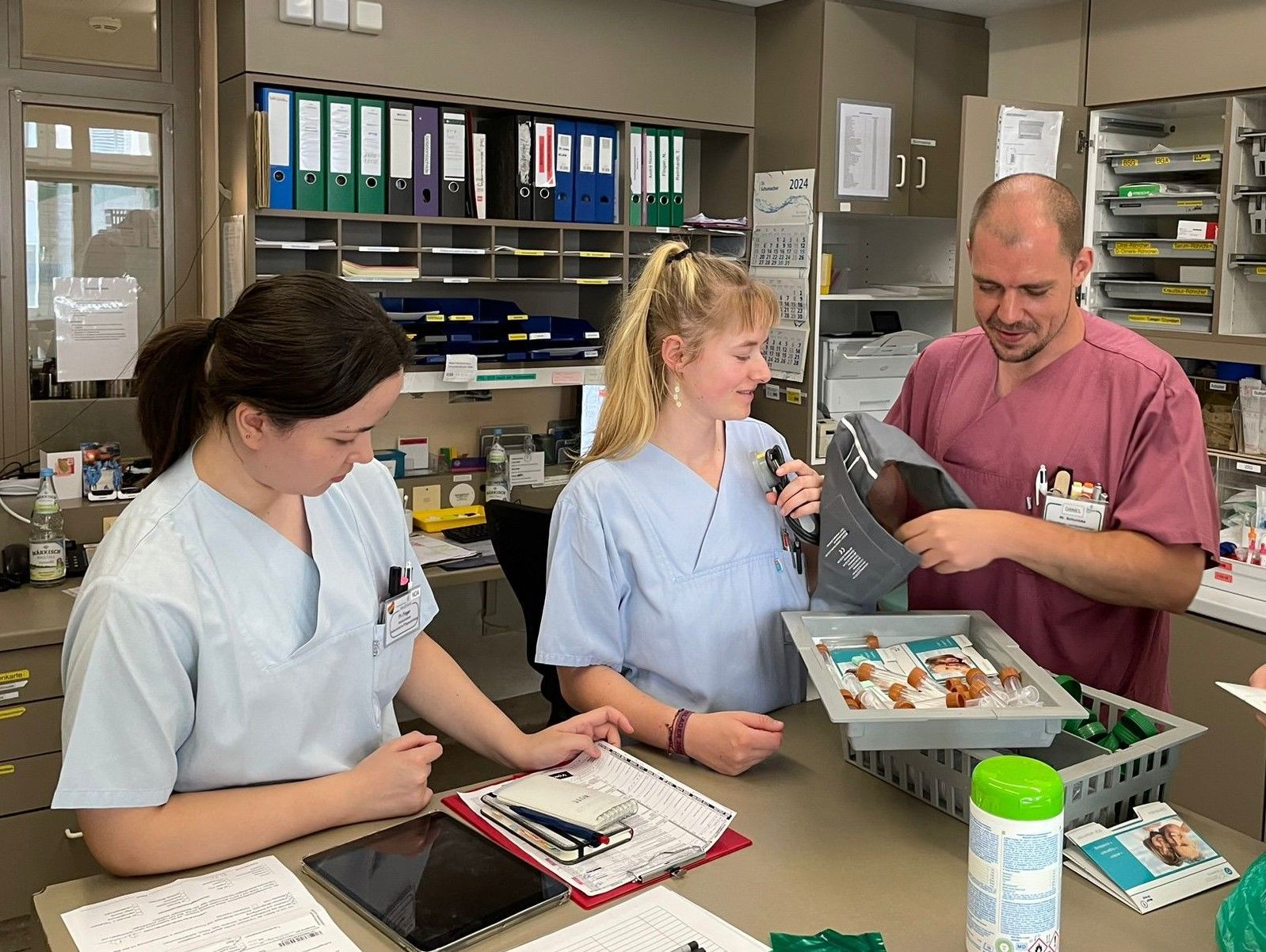 Eine Gruppe von Krankenschwestern sitzt in einem Krankenhaus an einem Tisch.