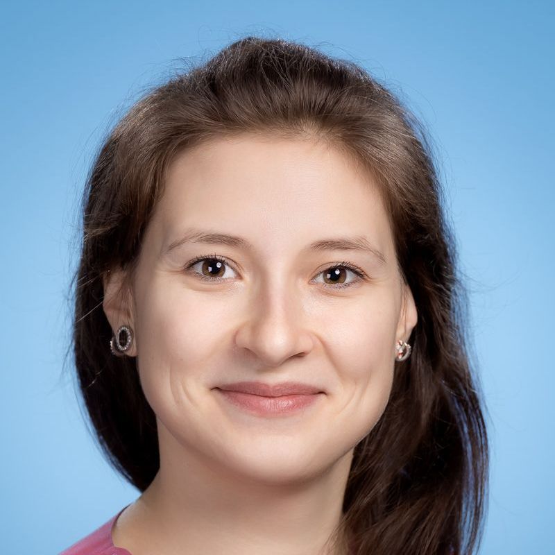 Eine Nahaufnahme des Gesichts einer Frau vor blauem Hintergrund.