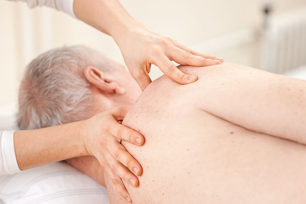 Ein älterer Mann bekommt von einer Frau eine Massage.