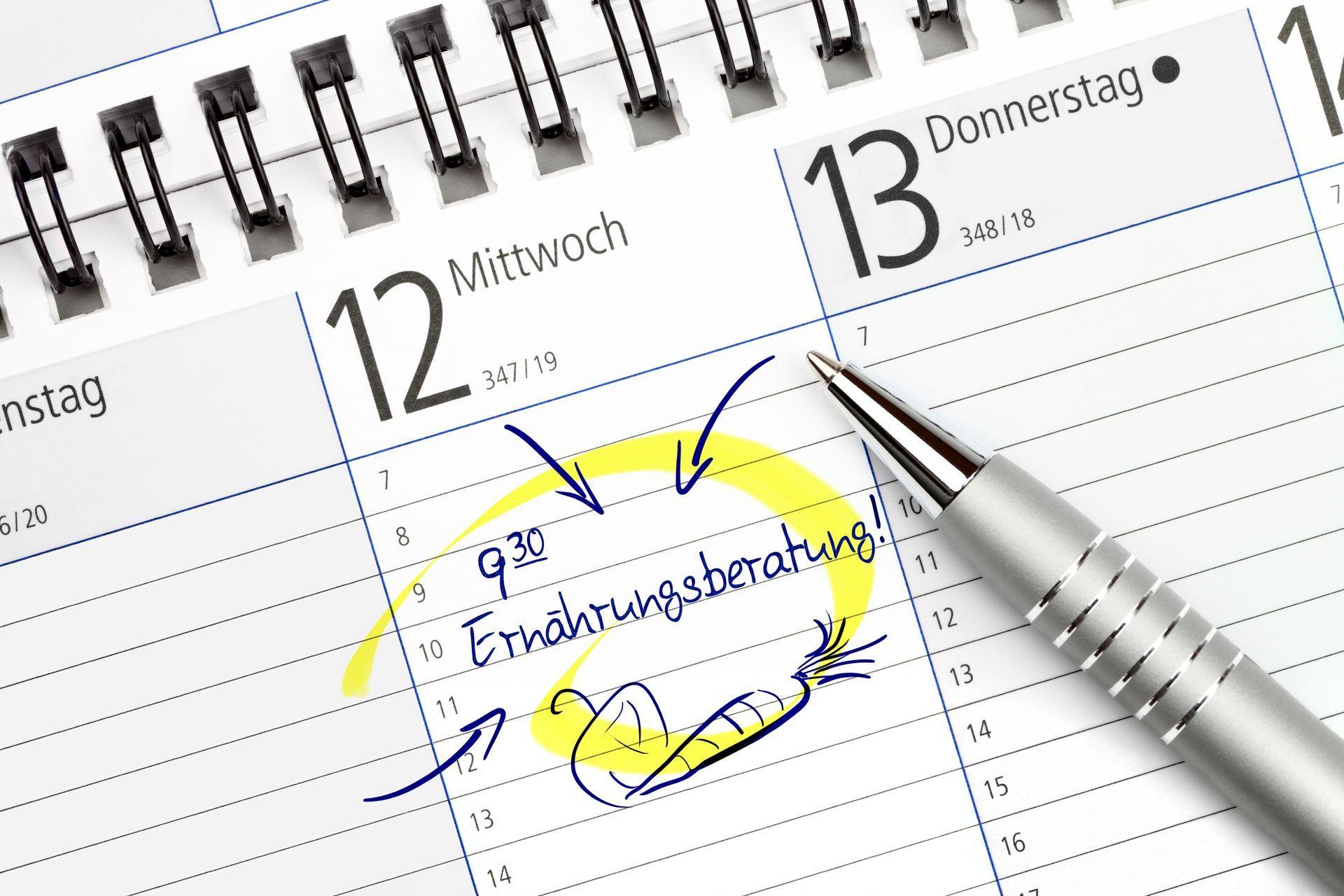 Ein Stift liegt auf einem Kalender, der das Datum als 13 anzeigt