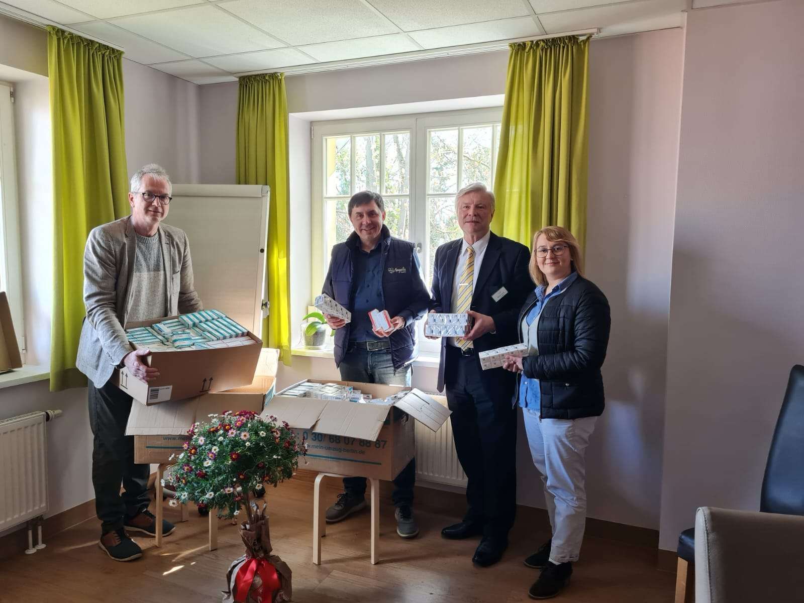 Eine Gruppe von Menschen steht mit Kisten in einem Raum.