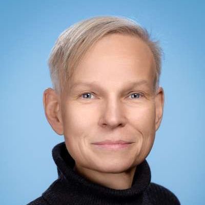 Ein Mann in einem schwarzen Rollkragenpullover lächelt in die Kamera.