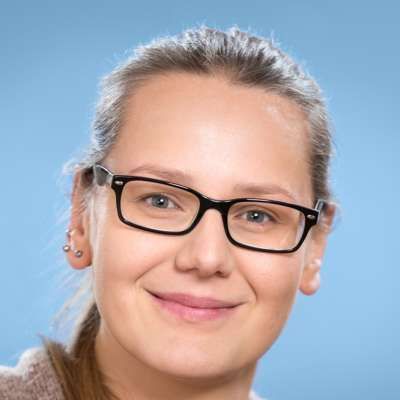Eine Nahaufnahme einer lächelnden Frau mit Brille.