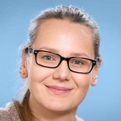 Eine Nahaufnahme einer lächelnden Frau mit Brille.