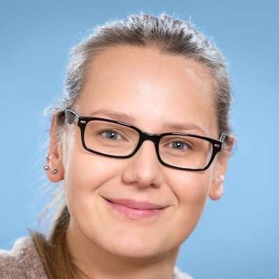 Eine Nahaufnahme einer lächelnden Frau mit Brille.