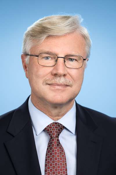 Ein Mann in Anzug und Krawatte mit Brille und Schnurrbart