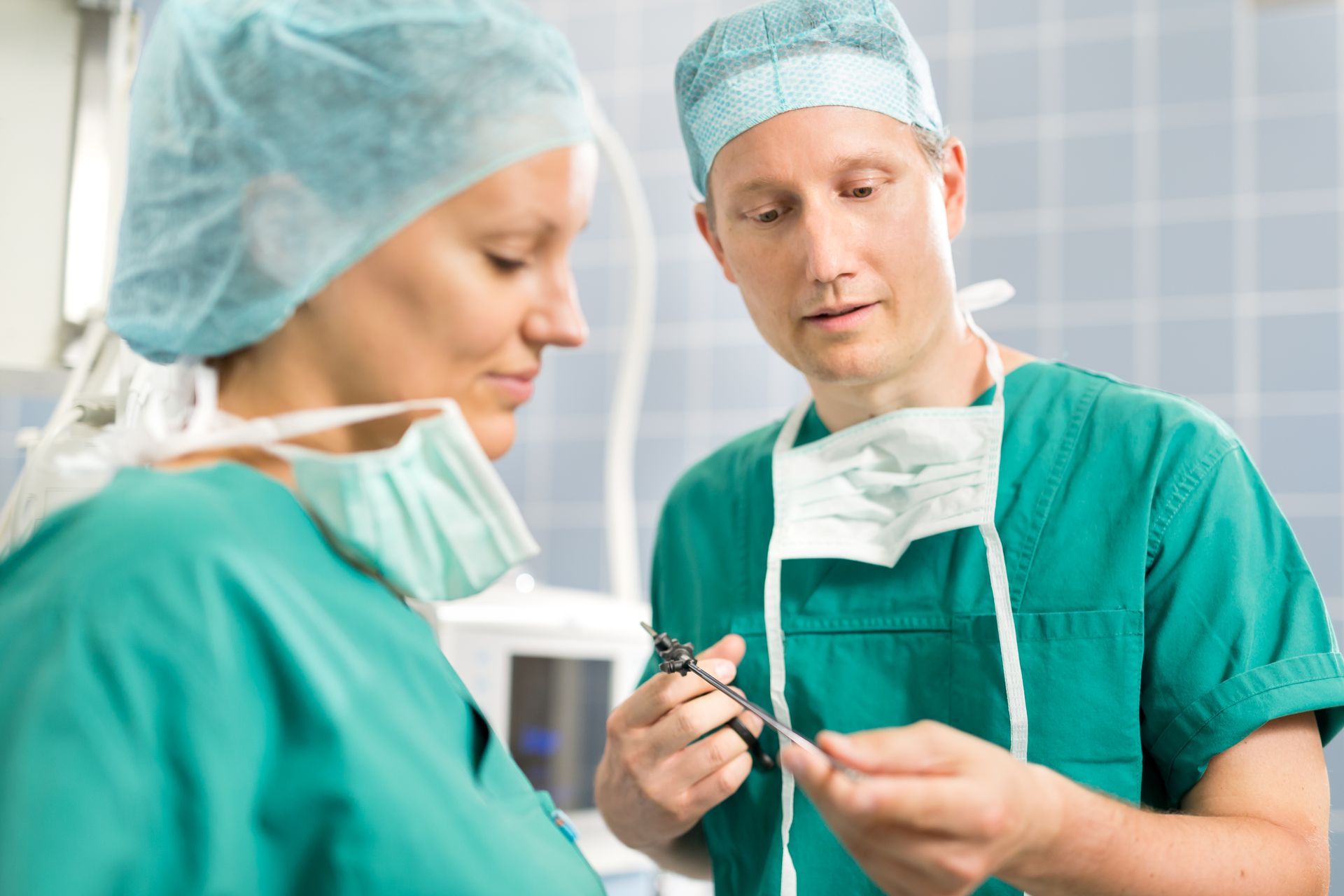 Ein Chirurg und eine Krankenschwester betrachten eine Schere.