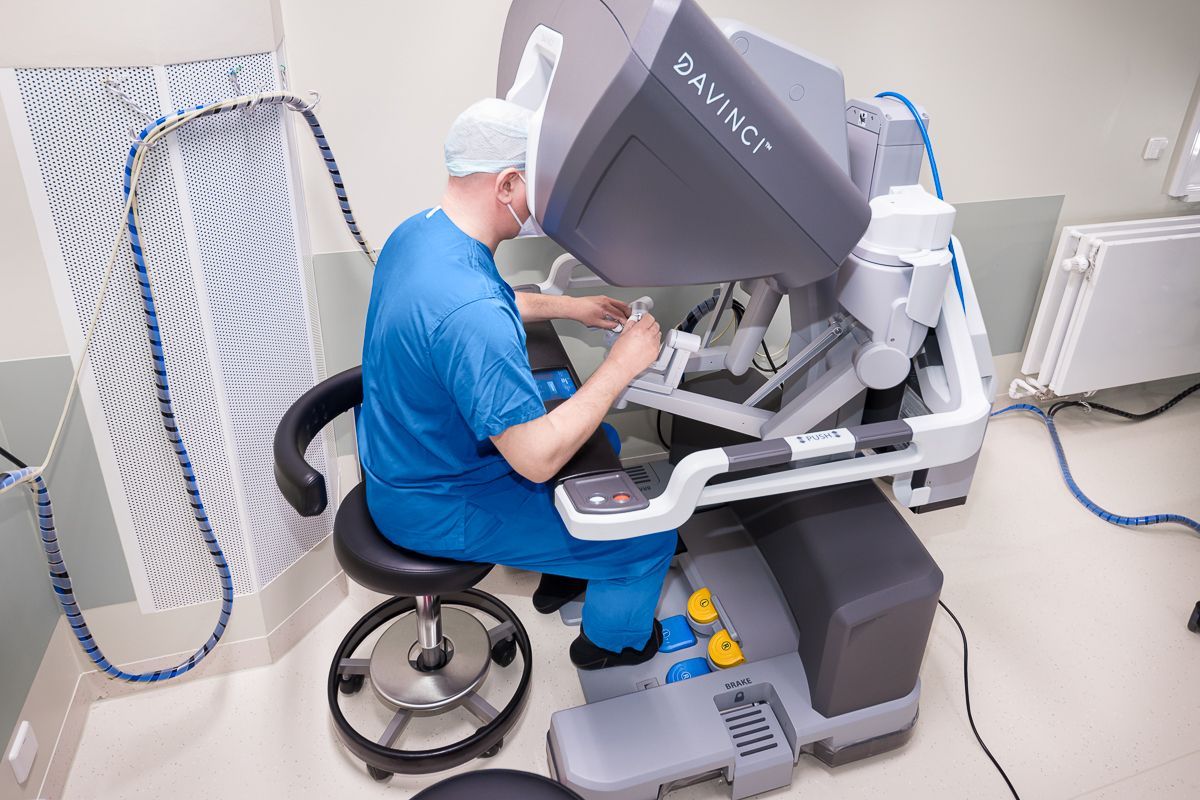 Ein Chirurg bedient in einem Operationssaal einen Roboter.
