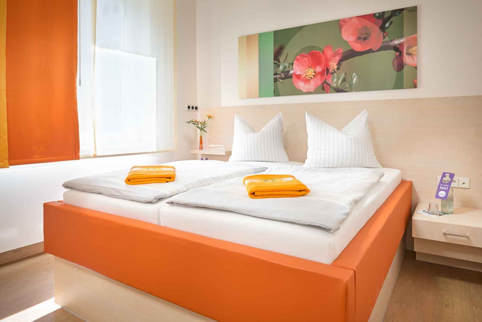 An der Wand über dem Bett hängt ein Blumenbild.