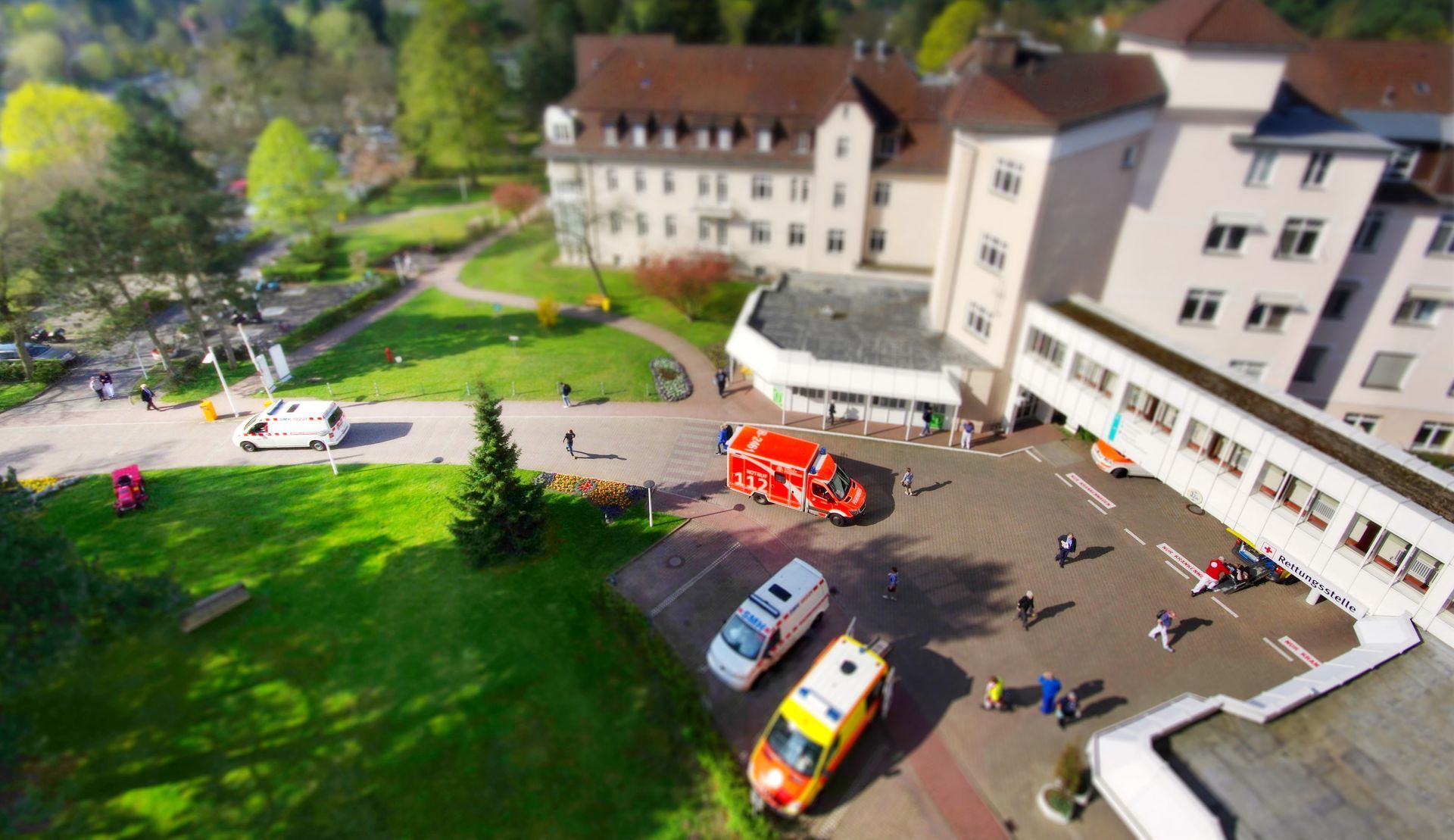 Eine Luftaufnahme eines Krankenhauses mit davor geparkten Krankenwagen.