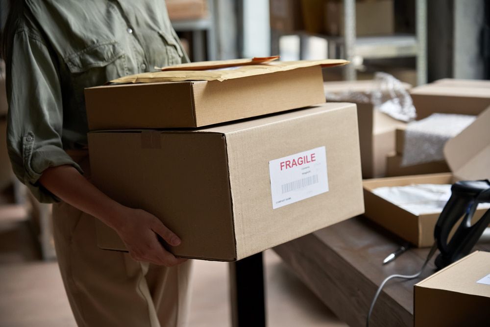 Person holding two cardboard boxes with a