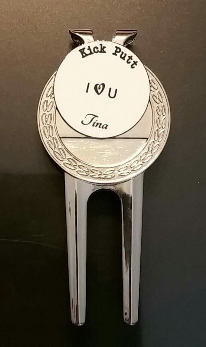 Silver golf divot tool with a circular marker, engraved