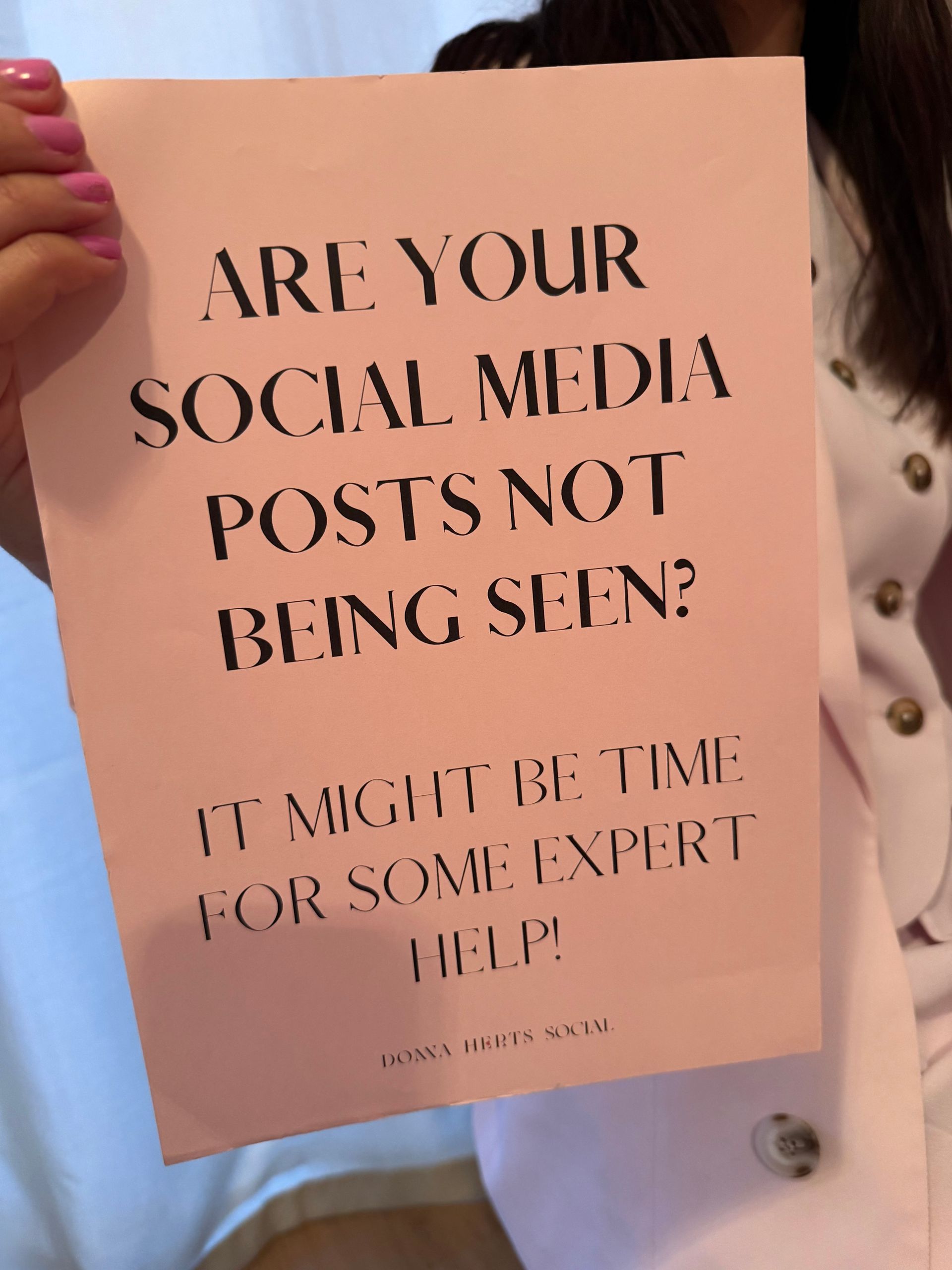 donna herts social holding a sign - instagram support - pink suit